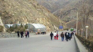 Where To Experience Local Life In Tehran 10 Visitors Walking Along A Paved Mountain Approach At Tochal, Tehran