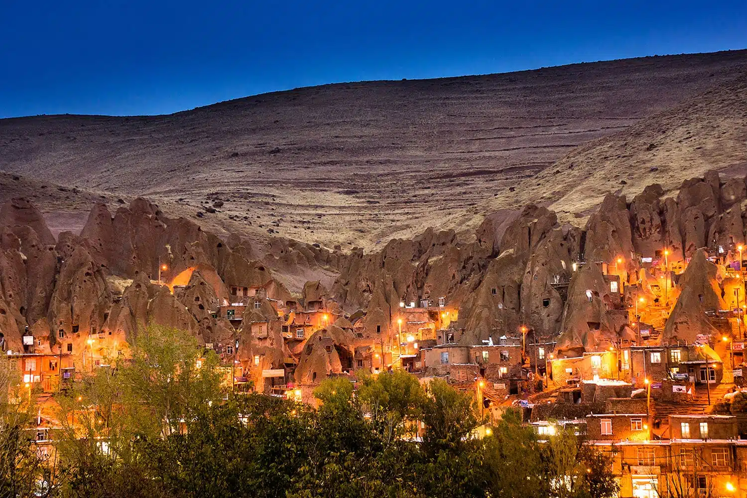 Kandovan is a unique village in Iran, known for its houses carved into volcanic rocks and scenic mountain views.